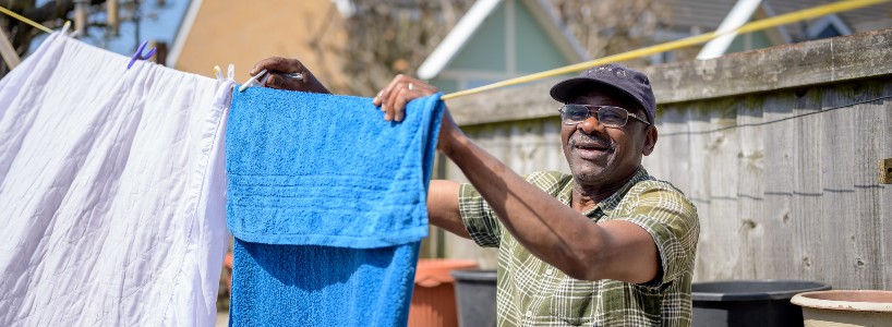 Man putting washing on clothes line and smiling